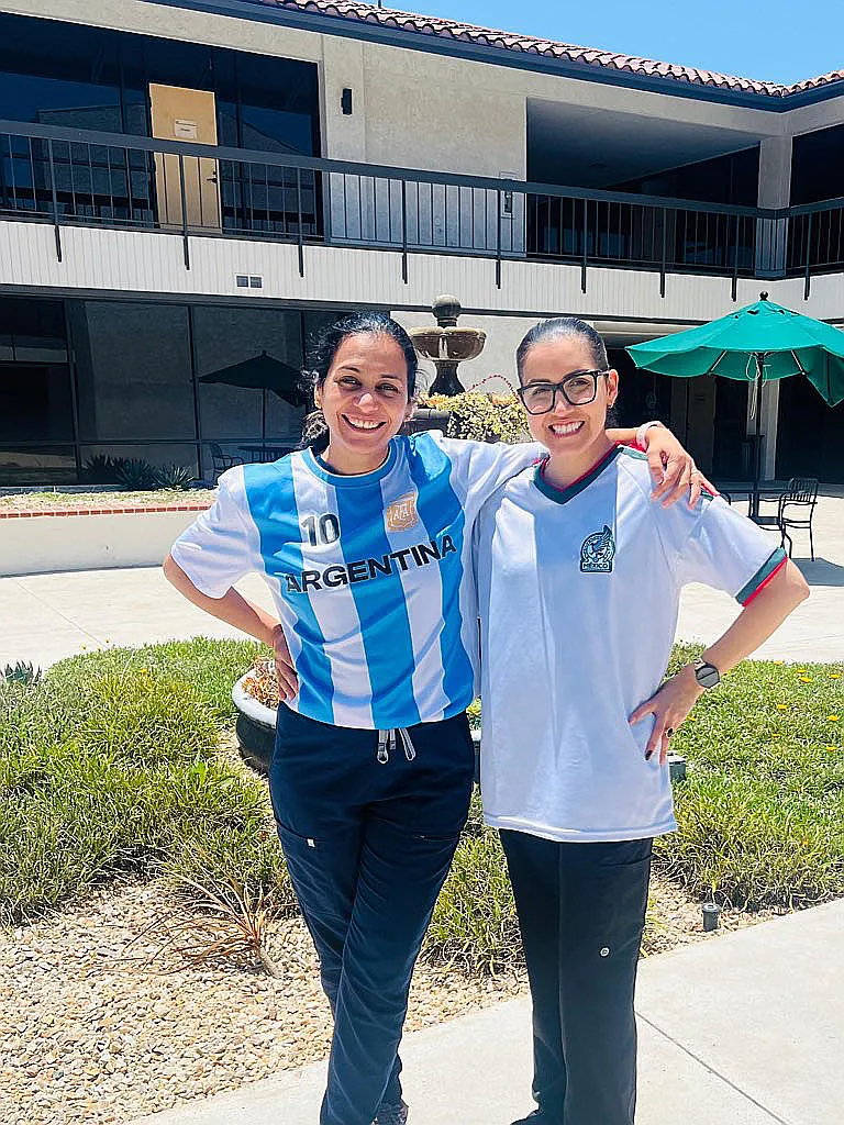 Two Real Dentistry team members in soccer jerseys outside the office