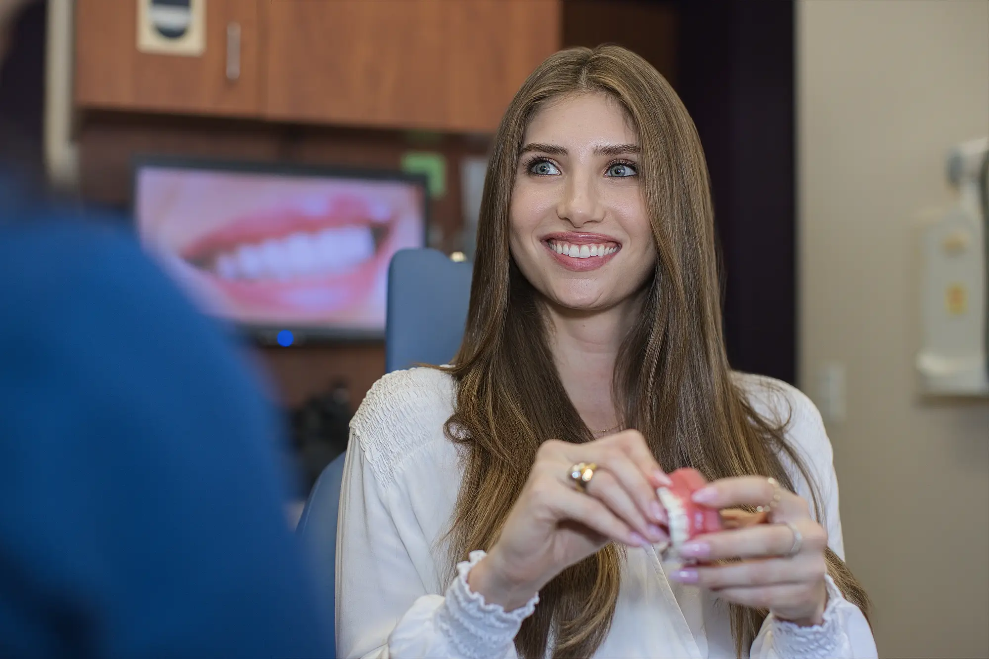 Young woman examining her clear aligner in the treatment room