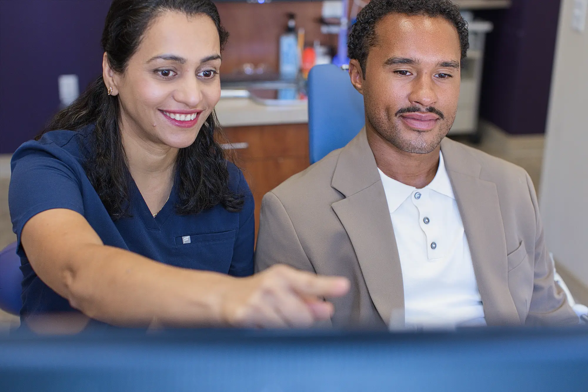 Dr. Trivedi and a patient reviewing his treatment plan on a screen