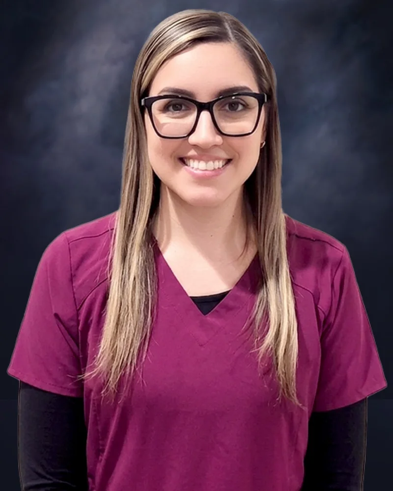 Anna, Registered Dental Assistant, in burgundy scrubs and glasses