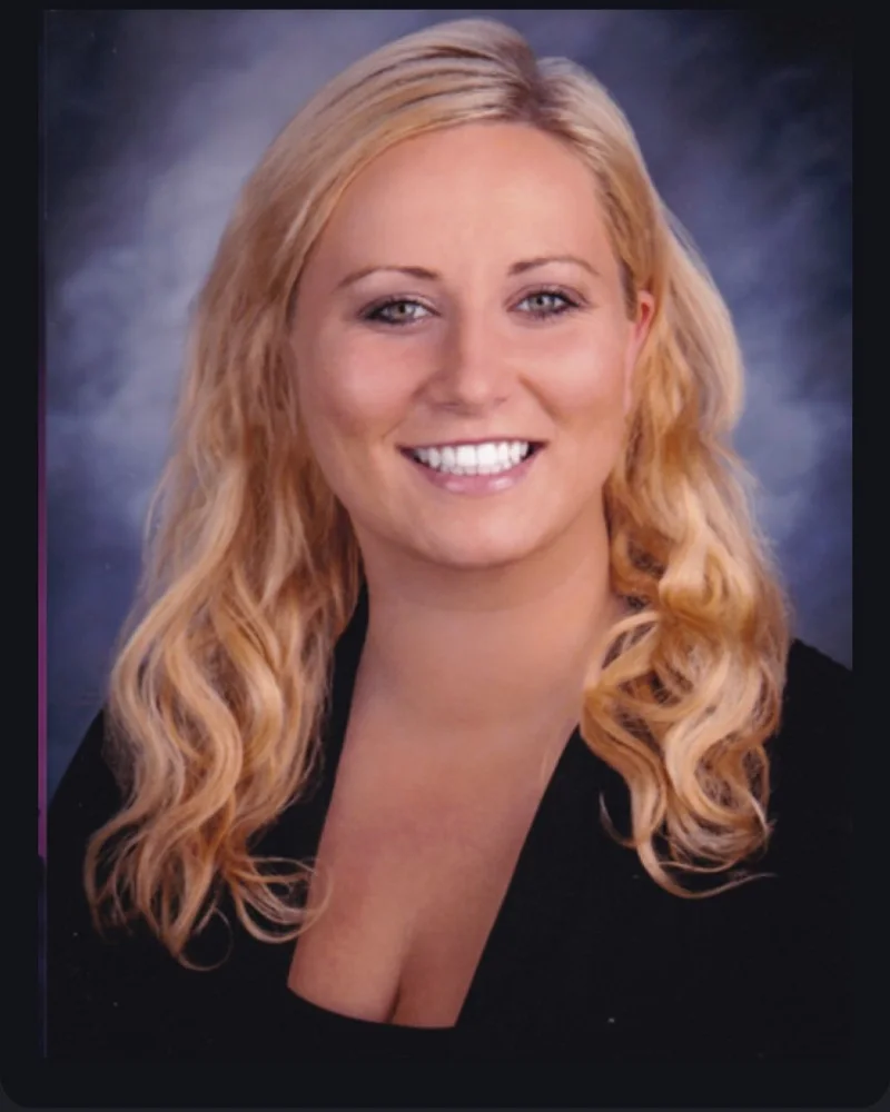 Larisa, Office Manager, smiling in a black top