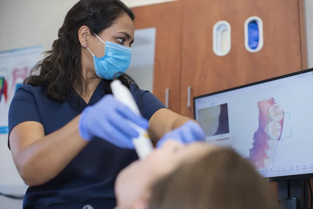 Dental assistant scanning a patient's teeth with a handheld intraoral scanner