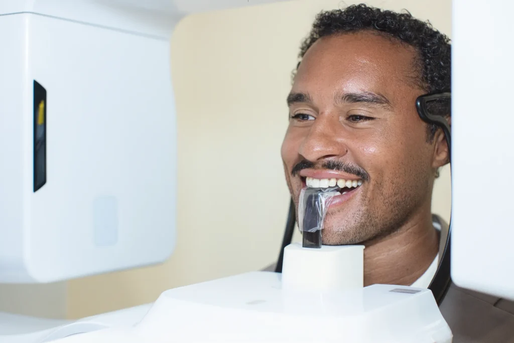 Smiling patient in a cone beam 3D imaging machine