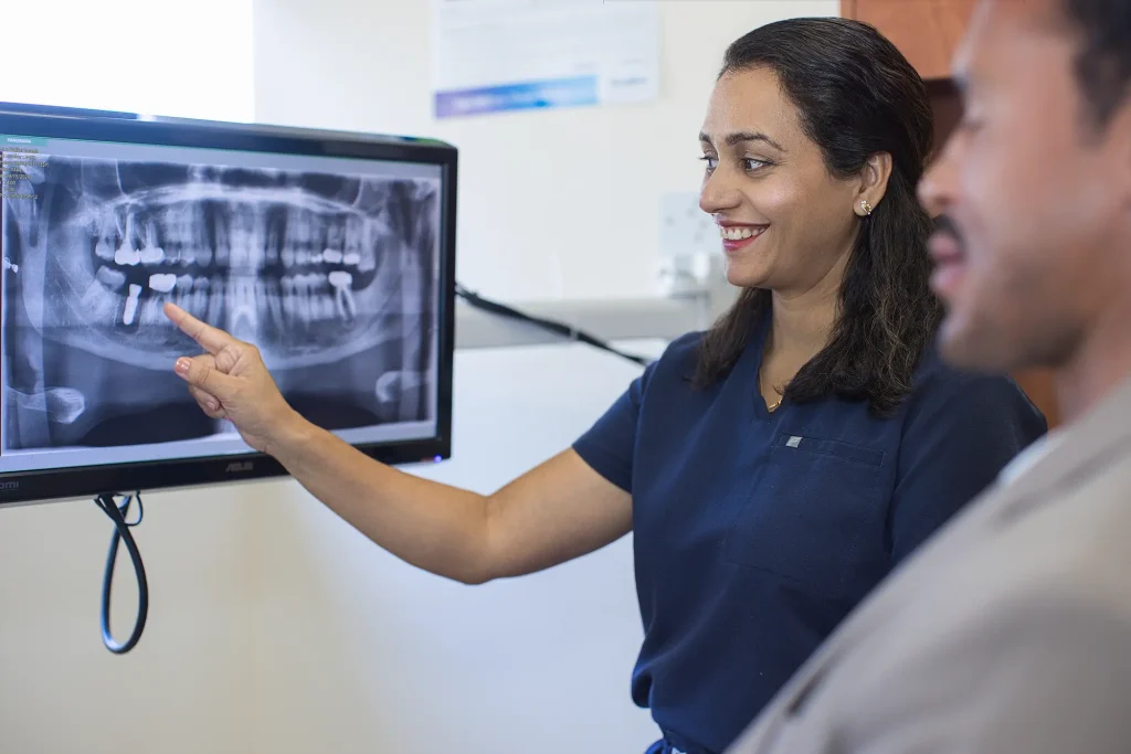Dr. Trivedi reviewing a panoramic X-ray with a smiling patient